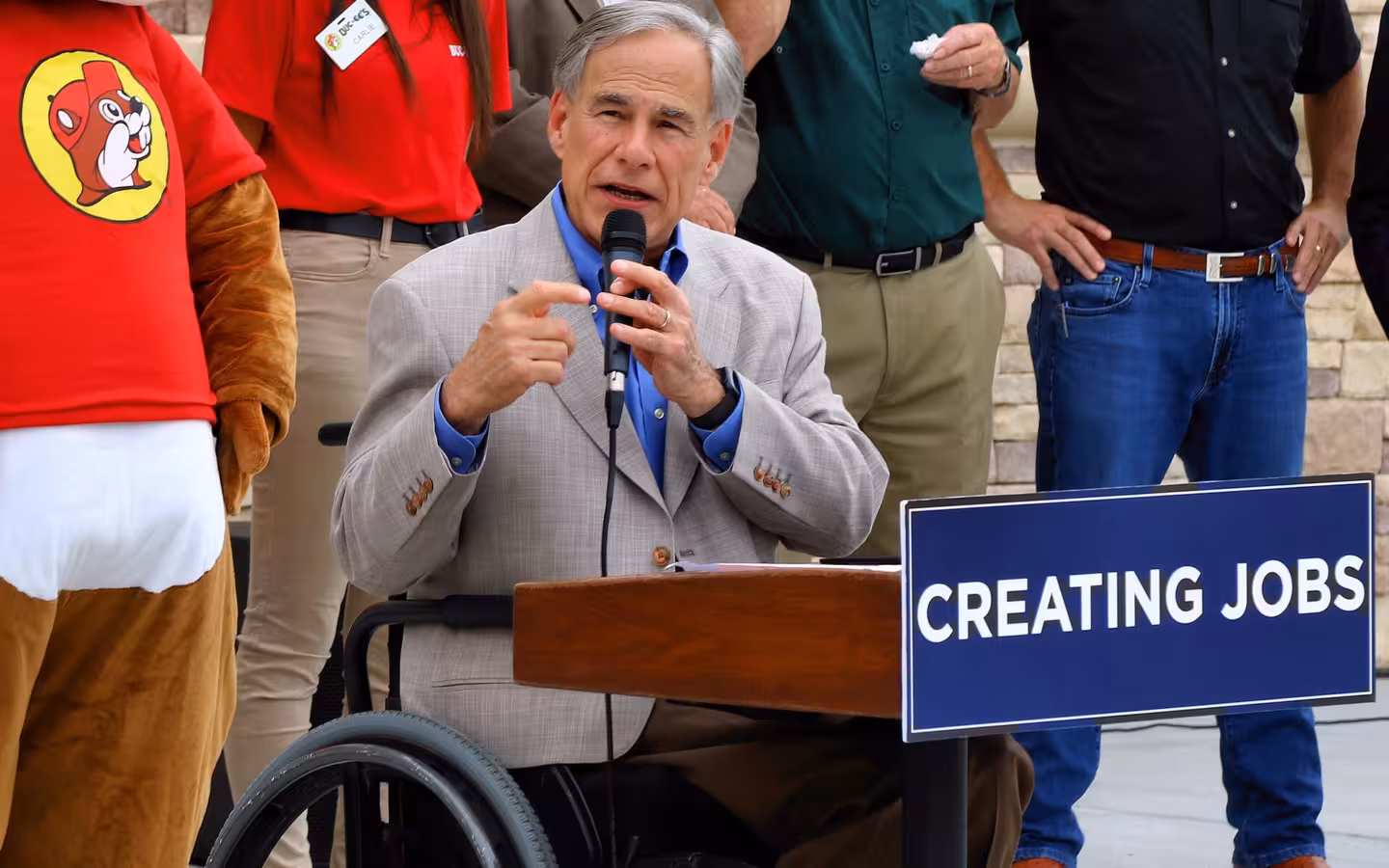 Texas Governor Greg Abbott speaking at a podium during Buc-ee's grand opening in Luling, Texas.