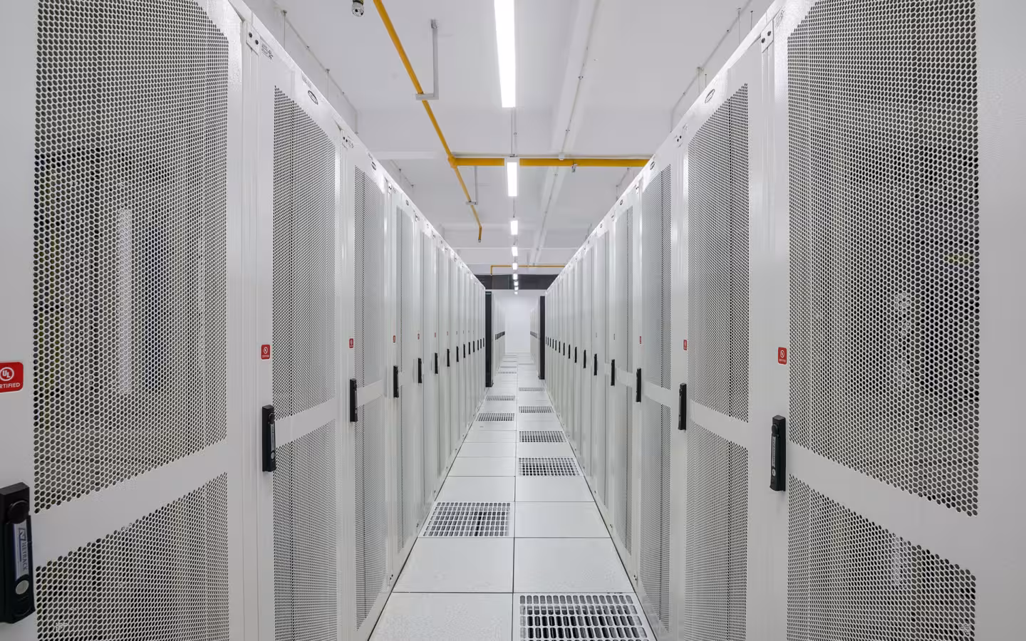 Rows of white server racks in Pi Data Centers aisle