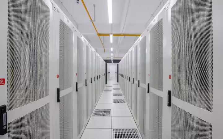 Rows of white server racks in Pi Data Centers aisle
