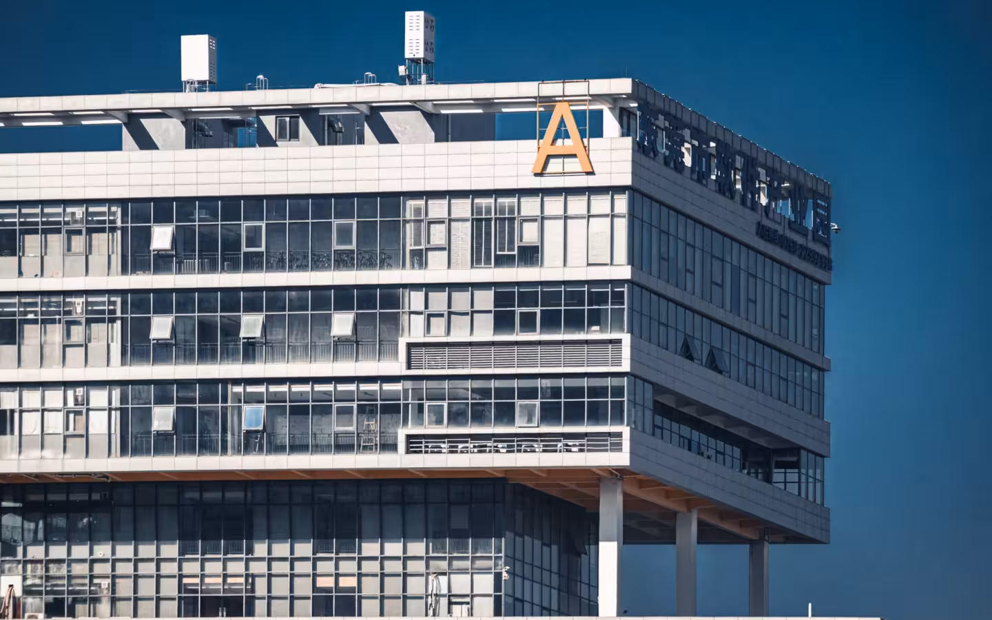 modern office building with glass facade under clear blue sky