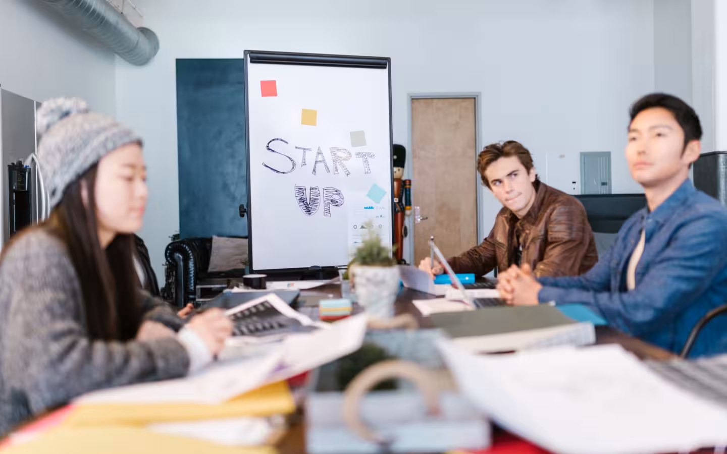 Group of young professionals brainstorming around a table in startup office