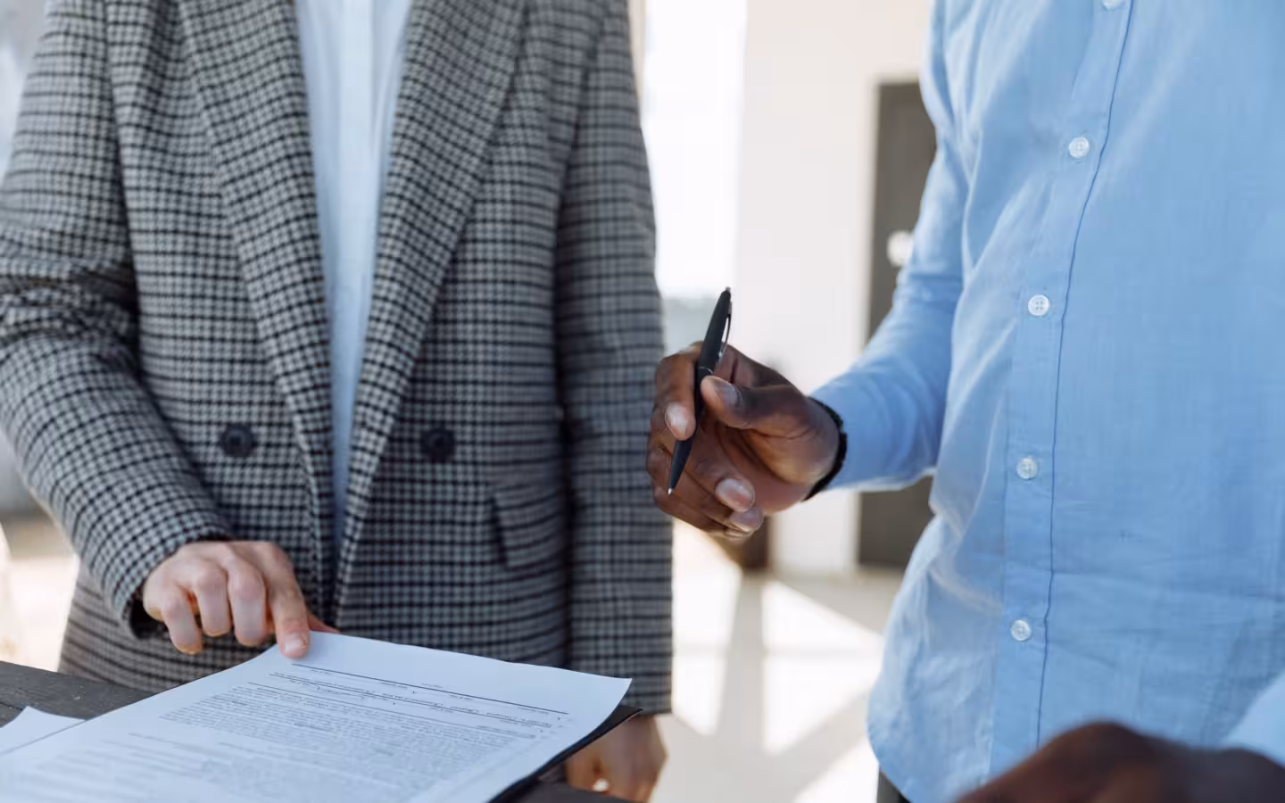 Two professionals reviewing business documents discussing details in office