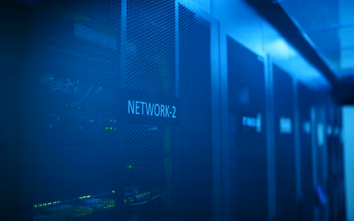 A modern server room with network equipment lit by blue illumination.