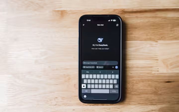 A smartphone on a wooden table showing an AI chatbot interface called DeepSeek