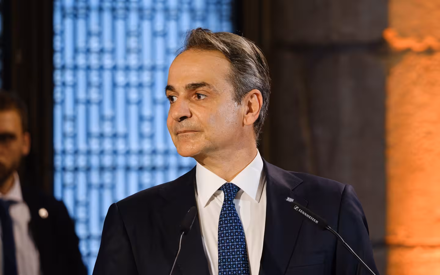 Kyriakos Mitsotakis speaking at a podium during Karlspreis ceremony