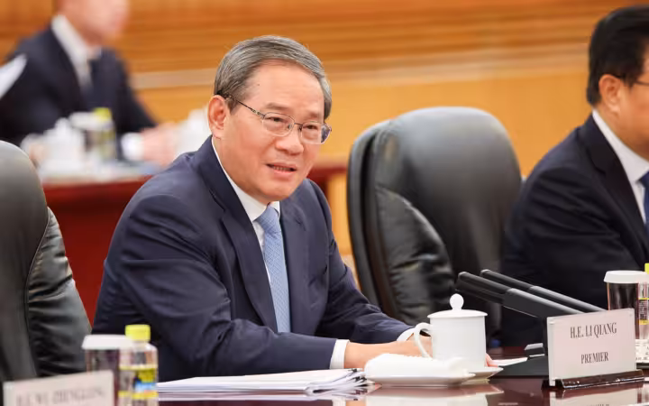 Li Qiang, Premier of China, sitting at a meeting table speaking