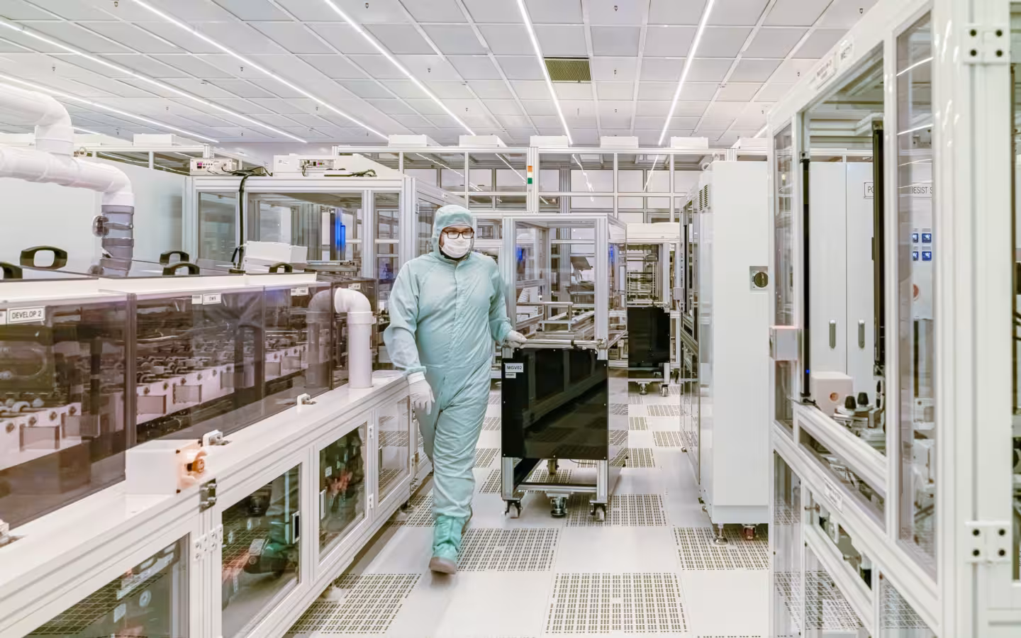 Scientist in protective gear walking in a high-tech cleanroom laboratory