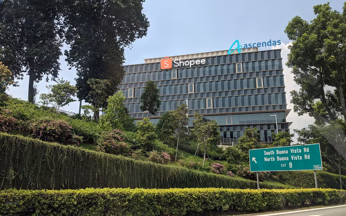 Shopee headquarters building with signage on a landscaped hillside