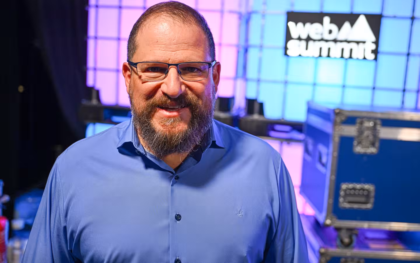 Cristiano Amon, bearded man in blue shirt, glasses, smiling
