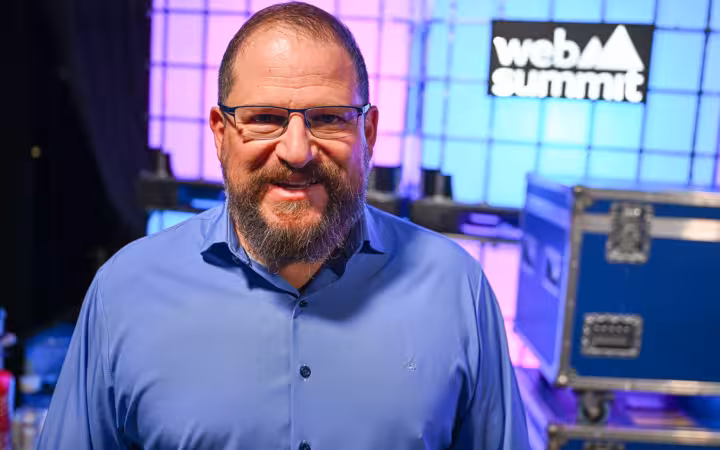 Cristiano Amon, bearded man in blue shirt, glasses, smiling