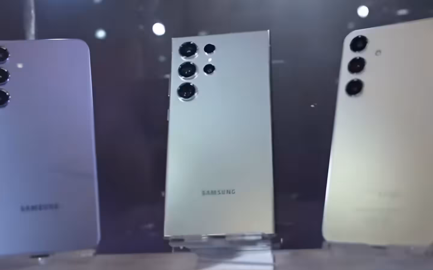 Three Samsung Galaxy s24 series smartphones displayed on stands.
