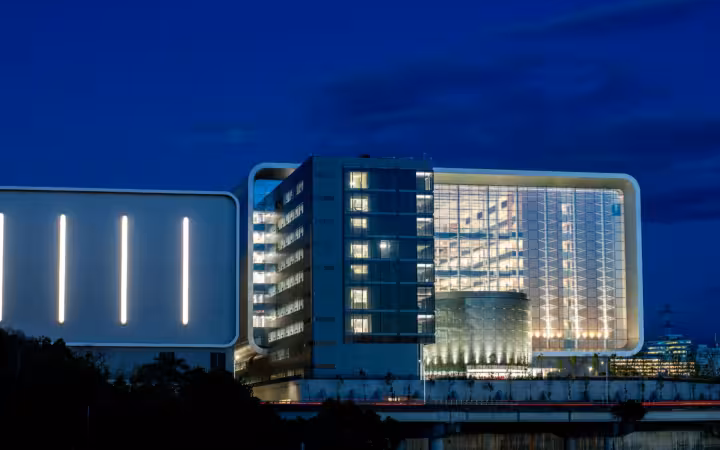 Illuminated TSMC Global R&D Center building at night against a dark blue sky.