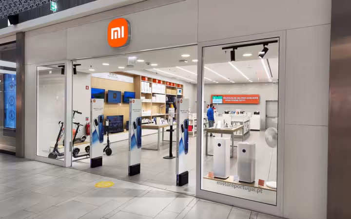 A brightly lit Xiaomi storefront in a shopping mall with products on display inside