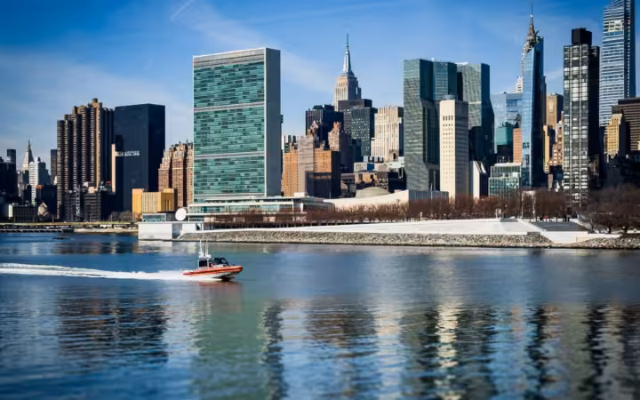 Boat passing United Nations Headquarters and surroundings on the East River