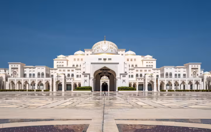 Qasr Al Watan Palace stands across a broad plaza beneath a clear sky.