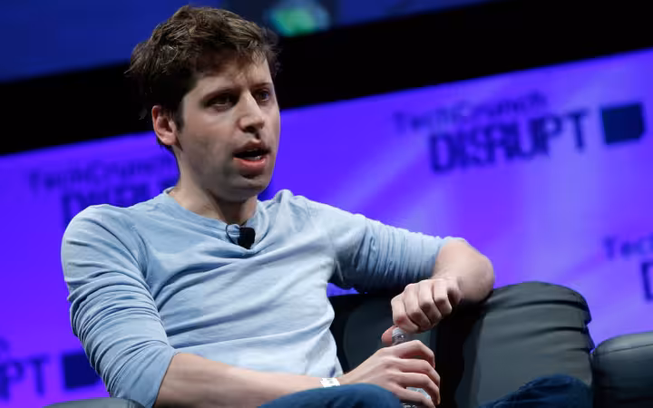 Sam Altman speaking onstage against a purple TechCrunch Disrupt backdrop