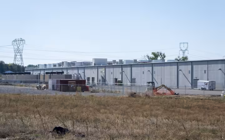 Amazon data center in Boardman, Oregon, beyond a field and power lines