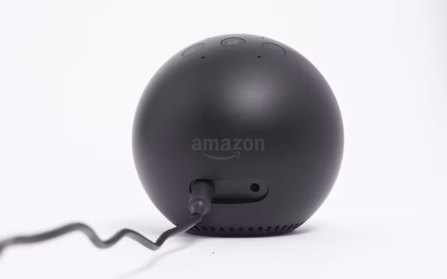 A black spherical Amazon device with a power cord against a white background