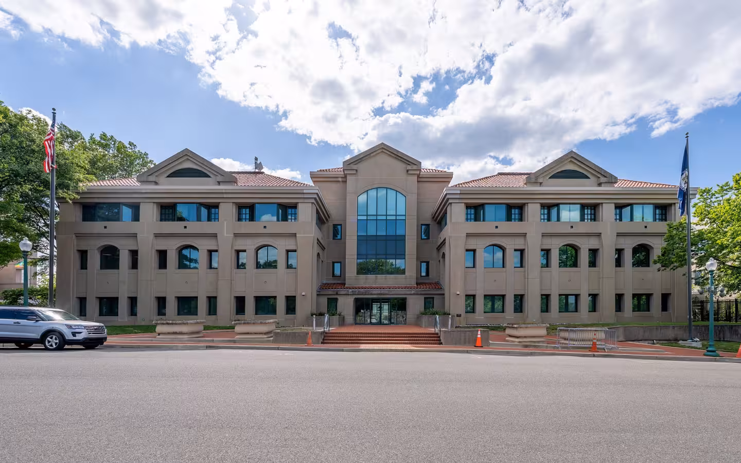 Office of Foreign Missions building across a road beneath partly cloudy skies