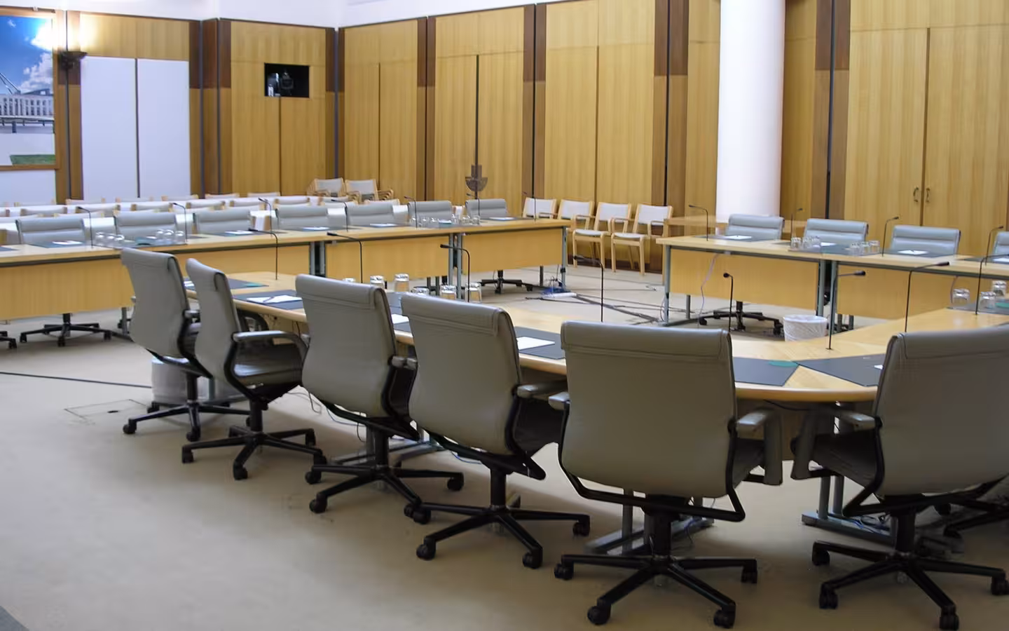Empty House of Representatives committee room in Parliament House, Canberra, with tables and chairs