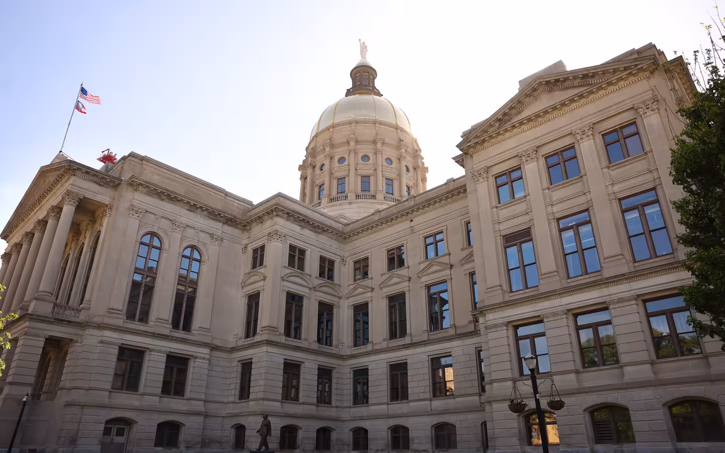 Georgia State Capitol’s domed exterior beneath a bright sky, with flags