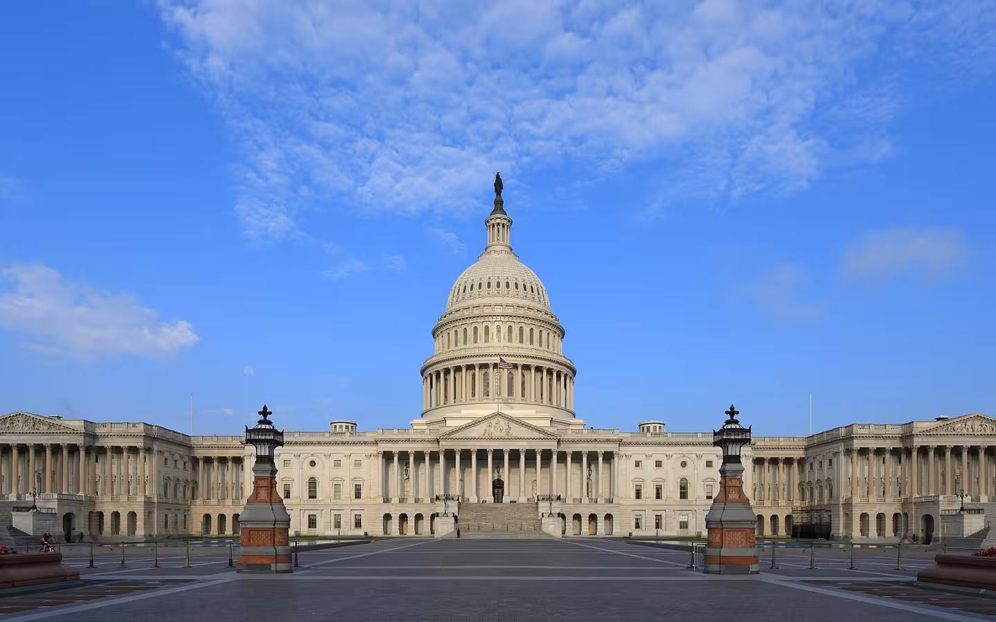 The United States Capitol east side beneath a blue, cloud-speckled sky