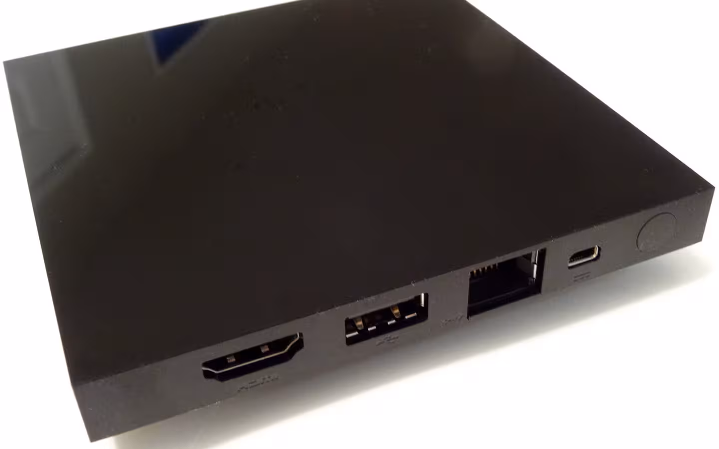 A black Android TV set-top box with HDMI, USB and Ethernet ports