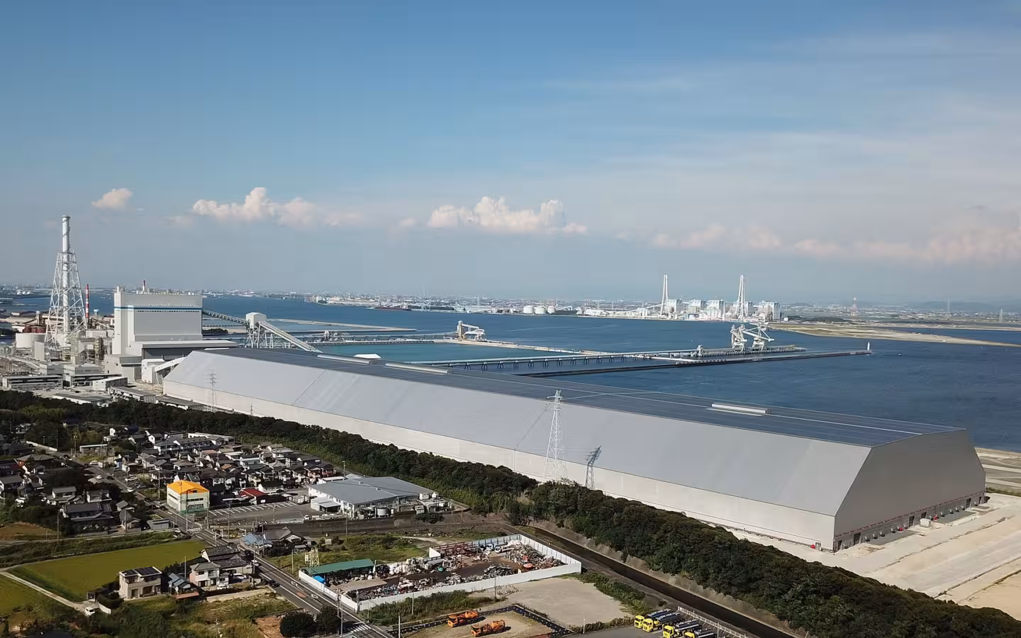 JERA Taketoyo thermal power plant beside the water, with houses in the foreground