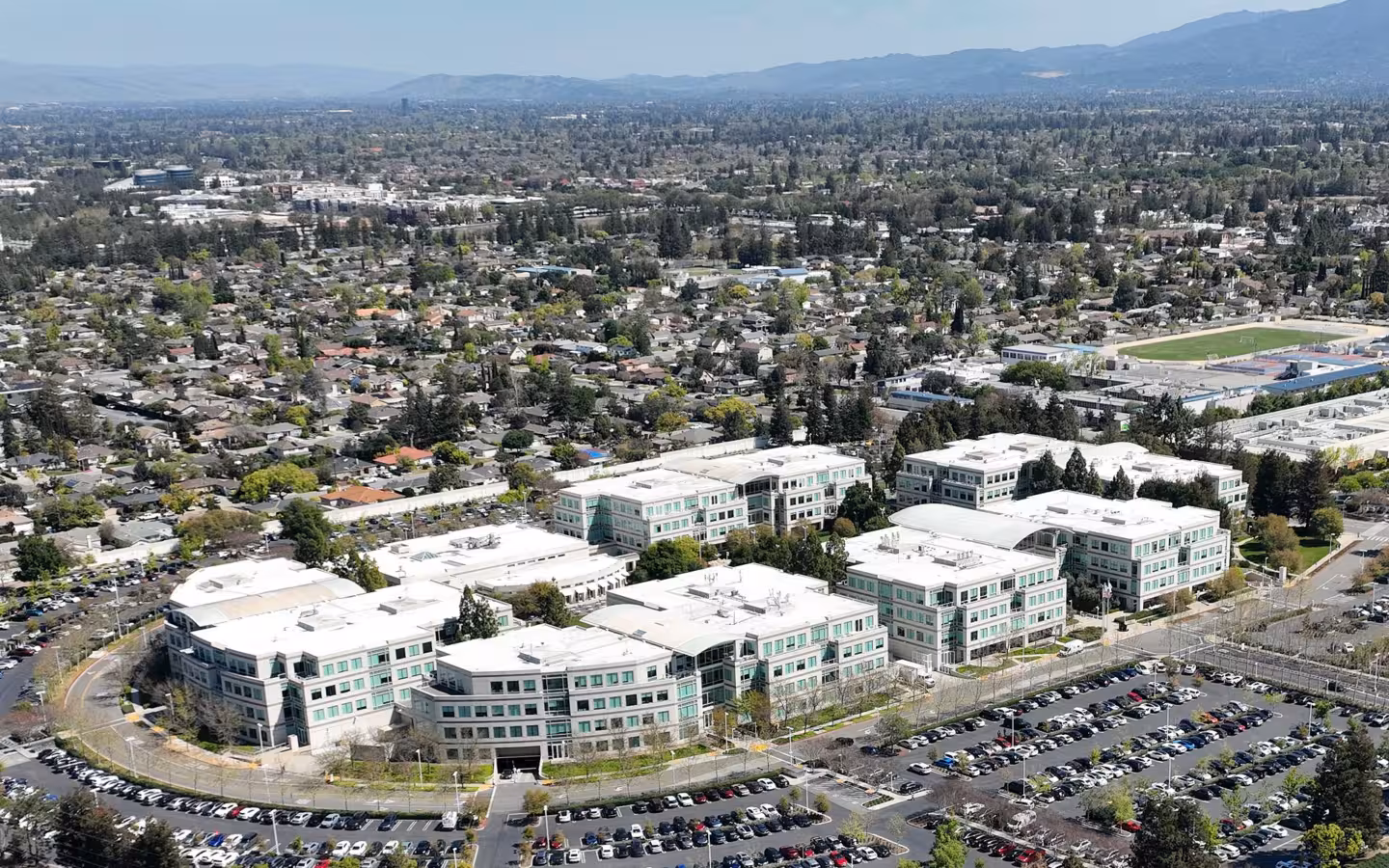 Aerial view of Apple's former Infinite Loop campus amid Cupertino neighborhoods.