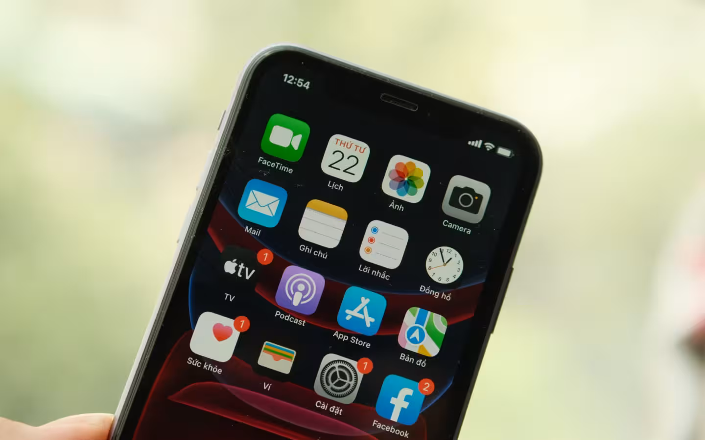 A tilted smartphone showing App Store and other apps against a blurred background