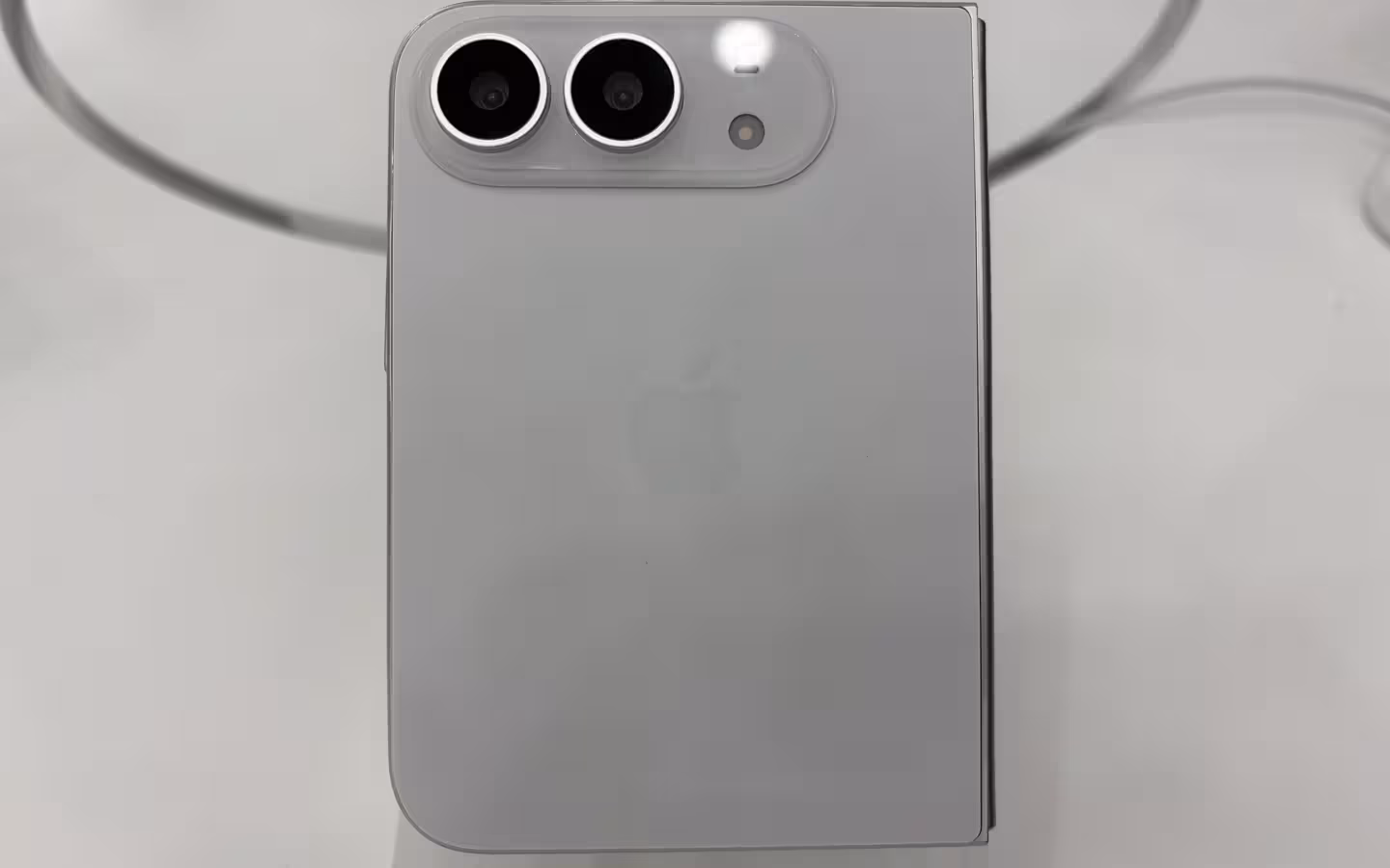 The rear of a white iPhone Duo, with two cameras and an Apple logo.