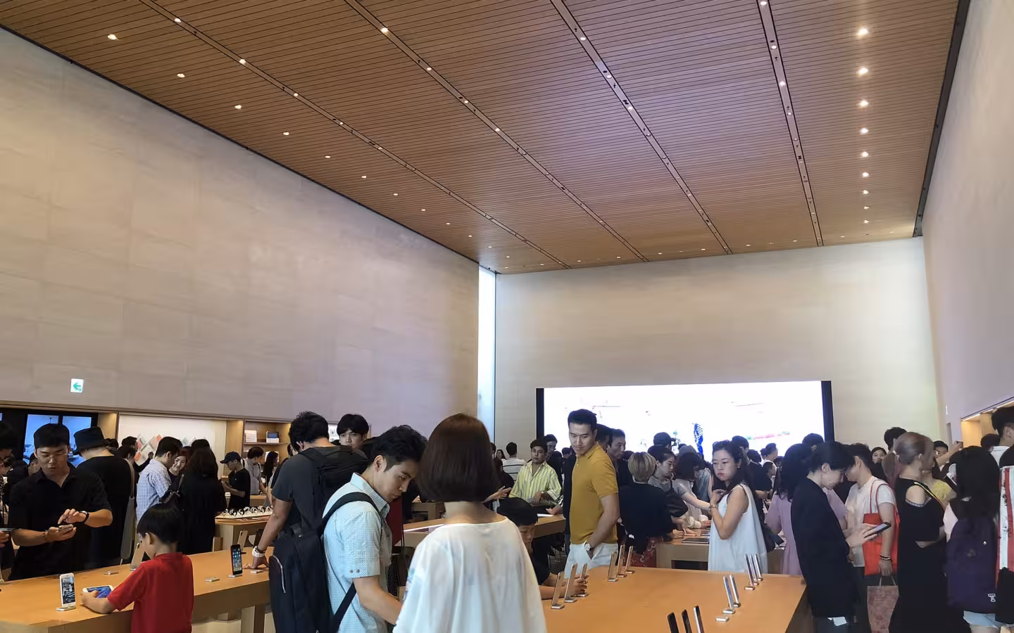 Customers browse devices inside the crowded Apple Garosugil store in Seoul.