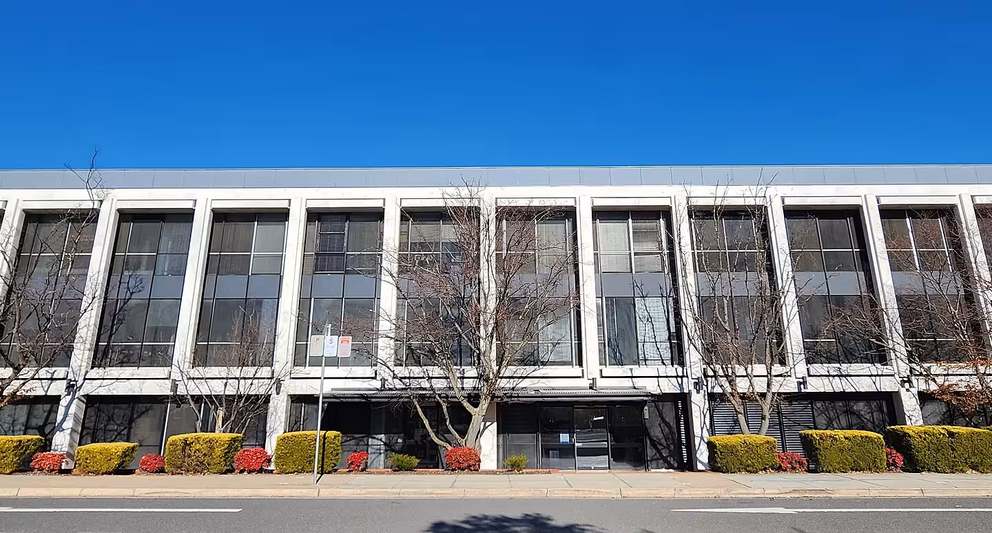 Reserve Bank of Australia building across a street beneath a blue sky