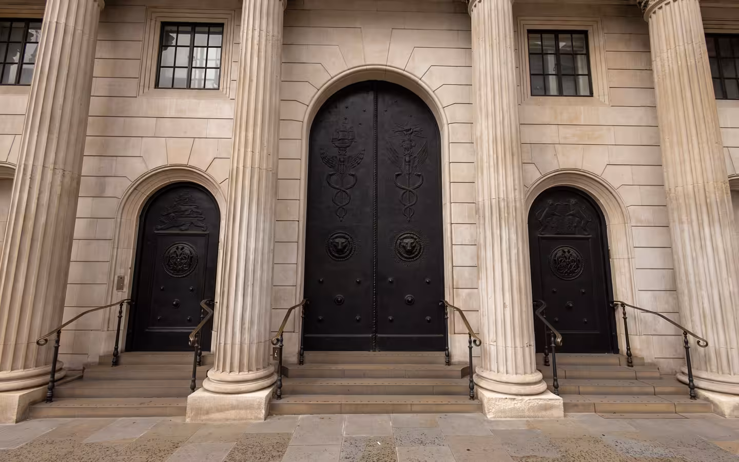 Bank of England entrance with three dark doors and stone columns