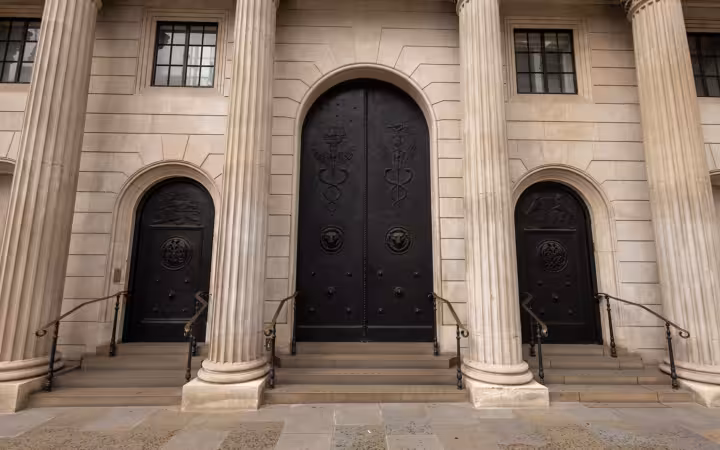 Bank of England entrance with three dark doors and stone columns