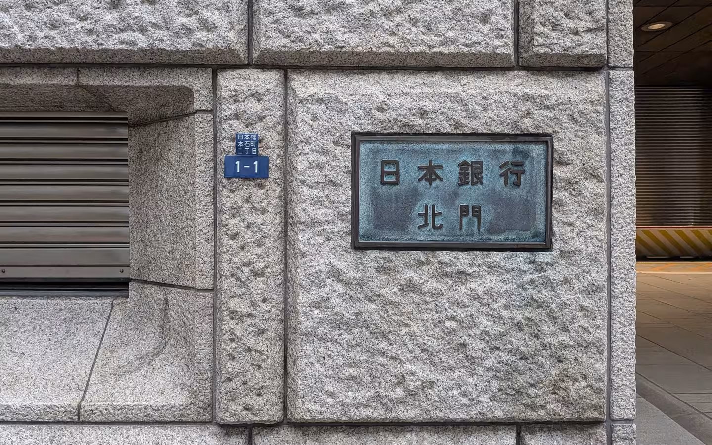 Stone facade of the Bank of Japan building with an entrance plaque