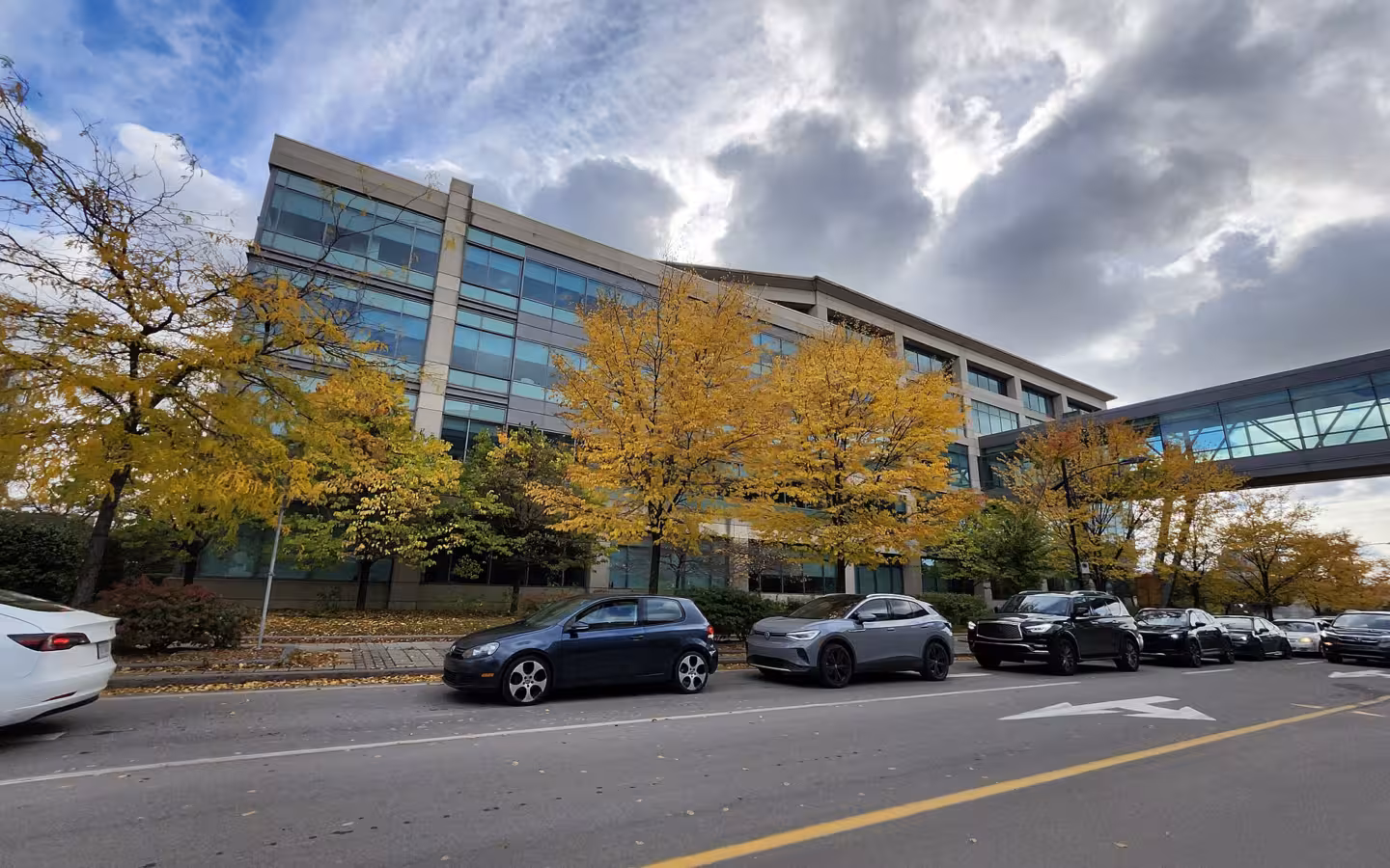 Campus Bell de l'Île-des-Sœurs with parked cars along the street under a cloudy sky