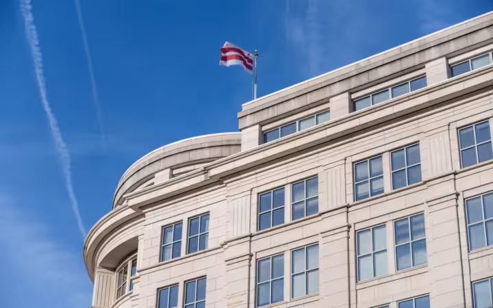 A building in Washington DC beneath a waving District of Columbia flag