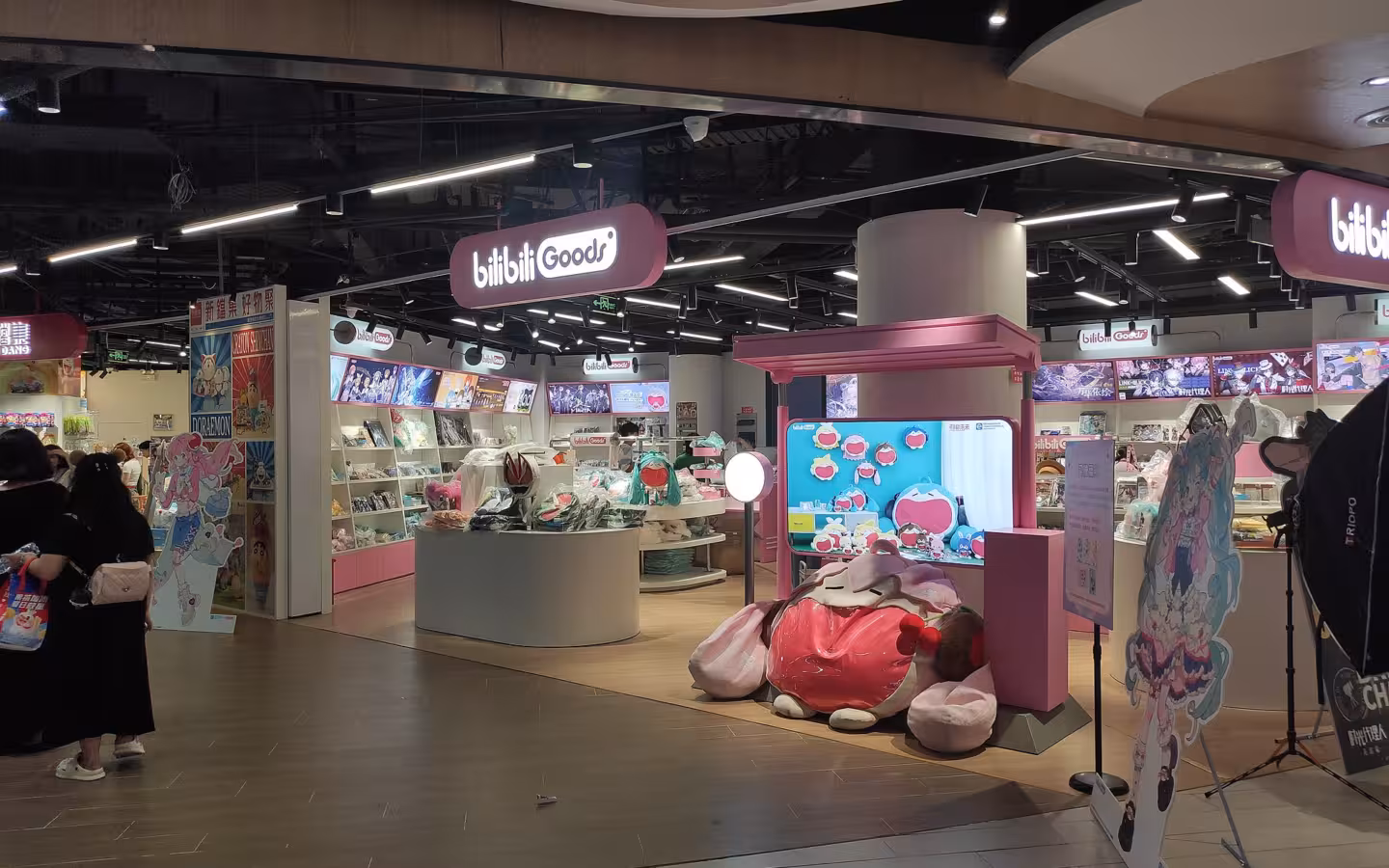 Bilibili Goods storefront with merchandise displays and shoppers at Nanjing Aqua City