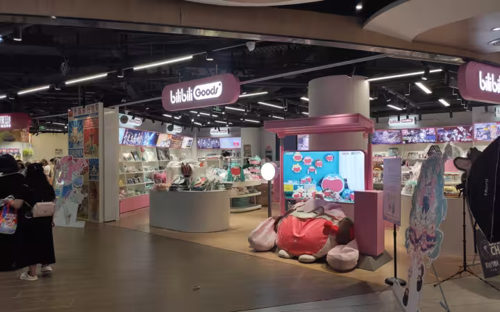 Bilibili Goods storefront with merchandise displays and shoppers at Nanjing Aqua City