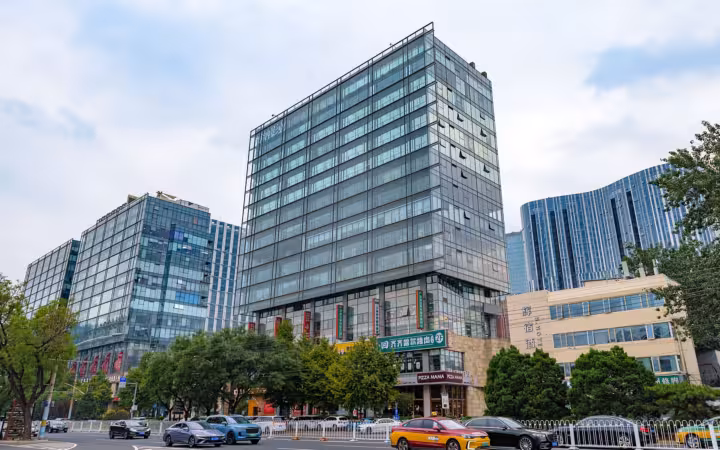 Bona Building rises above neighboring offices and street traffic in Beijing.