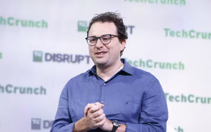 Anthropic CEO Dario Amodei speaking onstage before a TechCrunch Disrupt backdrop