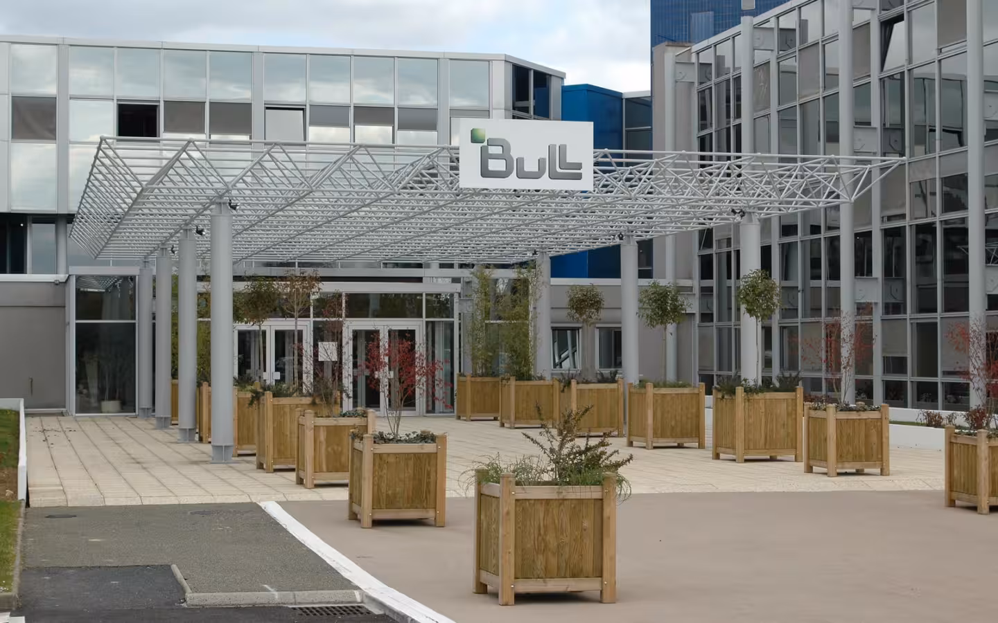 Bull headquarters entrance beneath a metal canopy, with planters outside