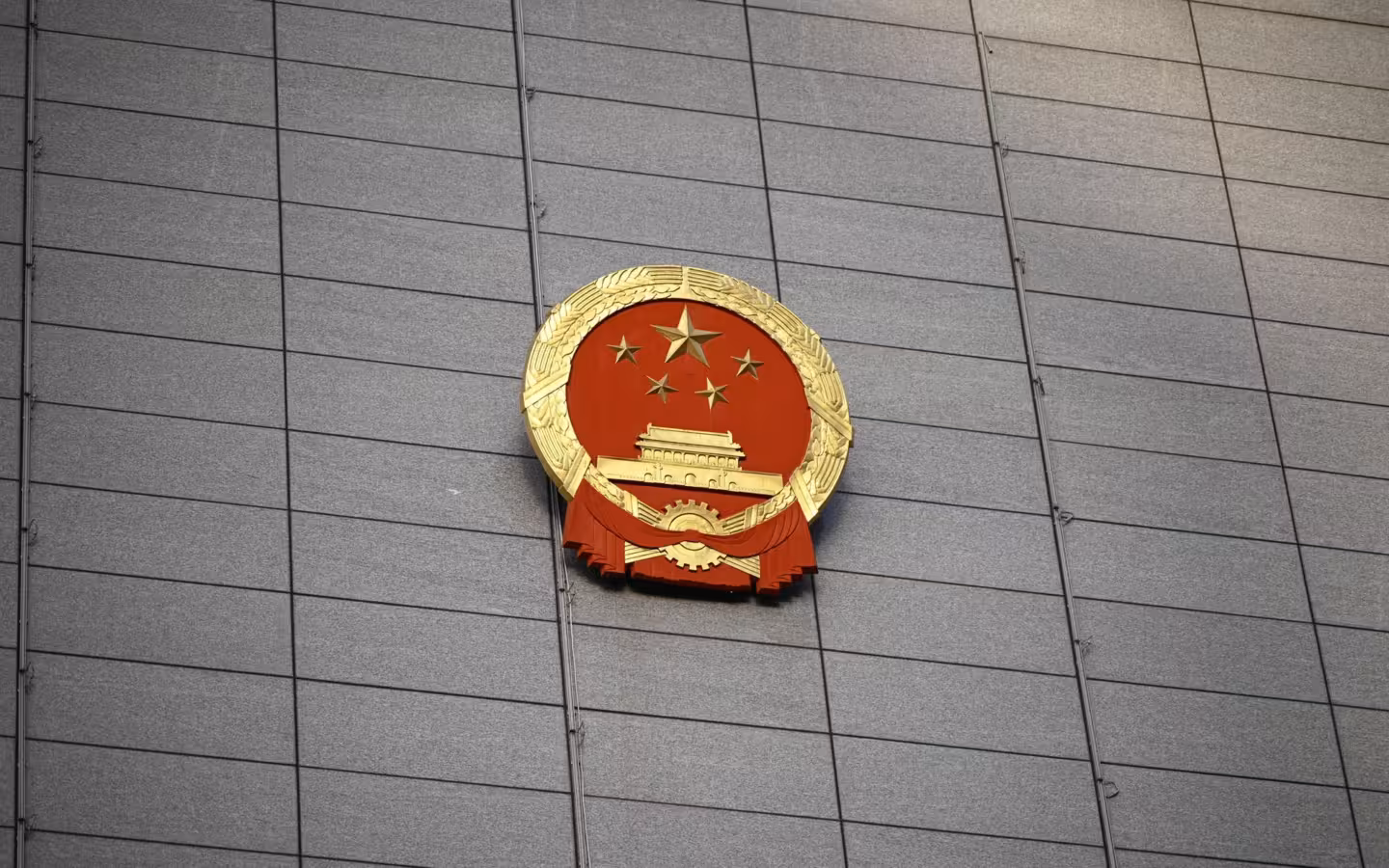 China’s national emblem mounted on a broad gray building facade