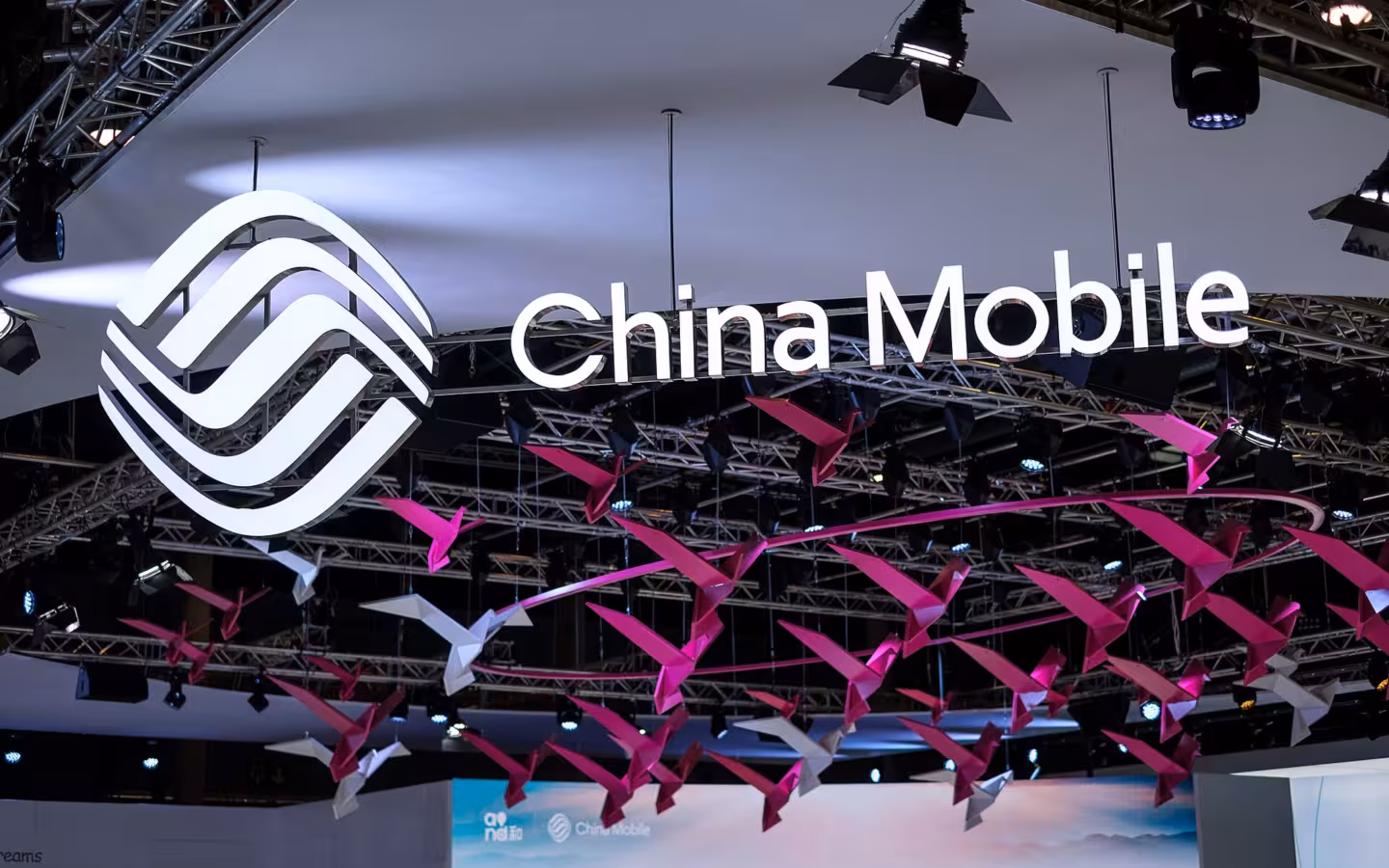 China Mobile logo and name hang above colorful decorations at an exhibition.