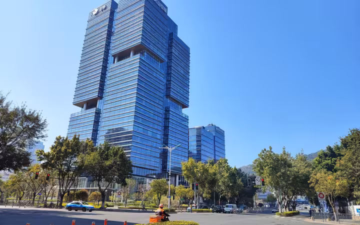 ByteDance’s Xiamen headquarters rises above a broad, tree-lined intersection.