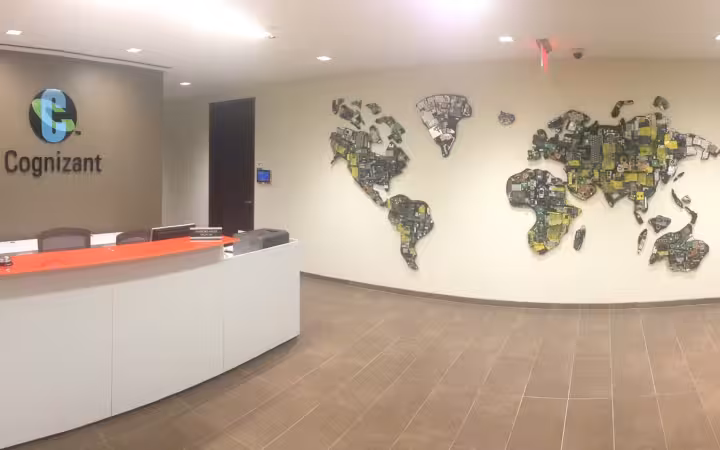 Cognizant sign above a reception desk and a world-map wall display