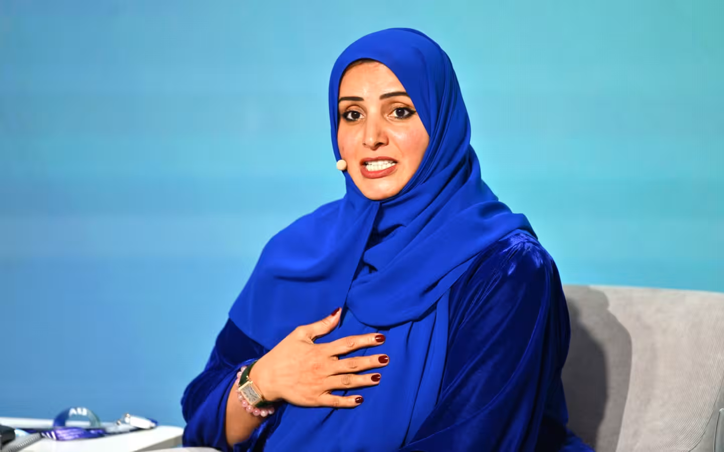 Aisha Bin Bishr speaks in a blue hijab at AI Journey conference.