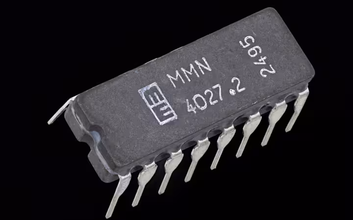 An MMN 4027 dynamic RAM chip isolated against a black background.