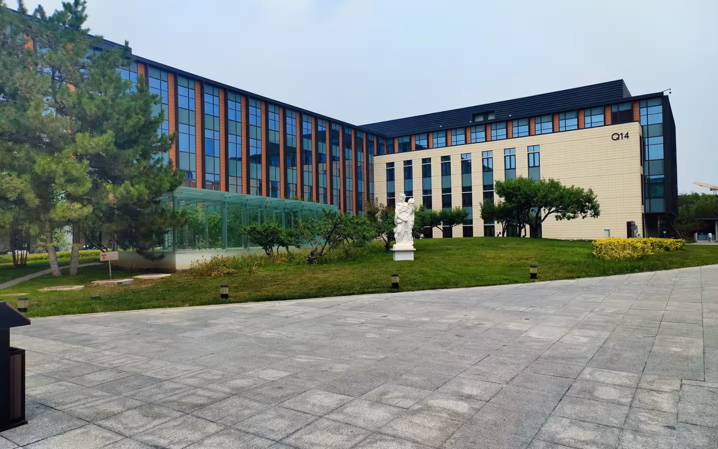 Huawei Beijing Research Institute Building Q14 beyond trees, lawn and a broad paved plaza